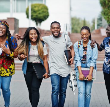 Group of five african college students spending time together on Group of five african college students spending time together on campus at university yard. Black afro friends studying. Education theme.